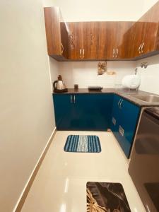 a small kitchen with blue cabinets and a stove at MIRA VISTA - Cozy 2 BHK Condo - Chennai in Siruseri