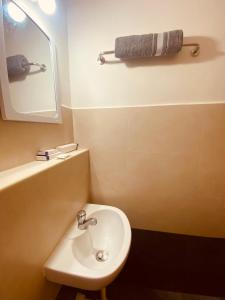 a white bathroom with a sink and a mirror at MIRA VISTA - Cozy 2 BHK Condo - Chennai in Siruseri