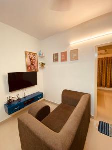 a living room with a couch and a flat screen tv at MIRA VISTA - Cozy 2 BHK Condo - Chennai in Siruseri