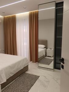 a bedroom with a bed and a large mirror at Marbel Apartments in Shëngjin