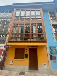 a building with a yellow door in front of it at El Albuergo in Llanes