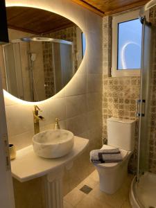 a bathroom with a sink and a toilet and a mirror at FK Apartment Sea View Balcony 60 m to the Beach Near Athens Airport and Rafina Port in Artemida +77 photos