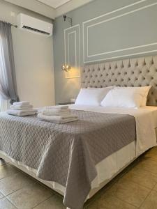 a bedroom with a large bed with towels on it at FK Apartment Sea View Balcony 60 m to the Beach Near Athens Airport and Rafina Port in Artemida