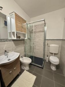 a bathroom with a toilet and a sink and a shower at Lago di Lugano - Casa Cecilia in Lavena Ponte Tresa +21 photos