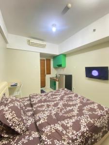 una camera da letto con un letto in una stanza di Apartment greenlake view by lens room a Pondokcabe Hilir