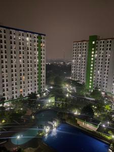 vista su una città di notte con edifici alti di Apartment greenlake view by lens room a Pondokcabe Hilir