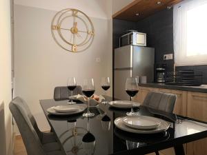 a dining room with a table with wine glasses at FK Apartment Sea View Balcony 60 m to the Beach Near Athens Airport and Rafina Port in Artemida