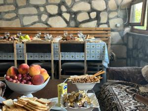 a table topped with a bowl of fruit and snacks at Adams Rest House in Yeghegnadzor