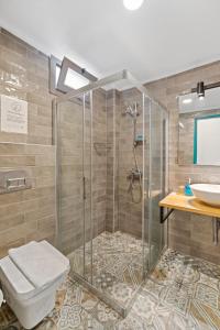 a bathroom with a shower and a toilet and a sink at Avlu Otel Palamutbükü in Datca