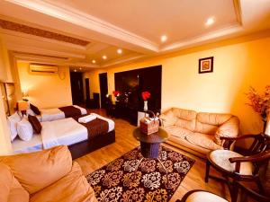 a living room with a bed and a couch at The Aqua Lodge, A budget friendly hotel - Haridwar in Haridwār