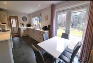 a kitchen with a table and chairs and a window at 6 Carn Dearg House in Aviemore