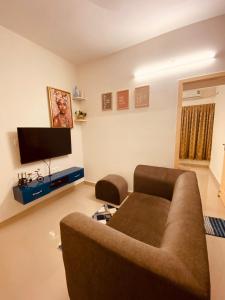 a living room with a couch and a flat screen tv at MIRA VISTA - Cozy 2 BHK Condo - Chennai in Chennai