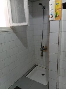 a shower in a white tiled bathroom at Joli chambre au coeur de tanger in Tangier