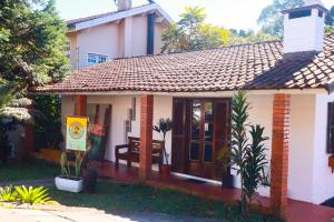 a small house with a bench in front of it at Gramado Guest House in Gramado