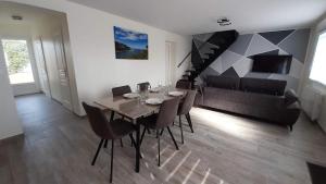 a dining room with a table and chairs and a couch at Le Nid de la Baie in Pendé