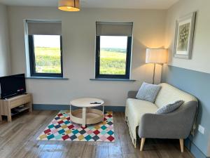 a living room with a couch and a table at Natures Rest Apartment in Doolin