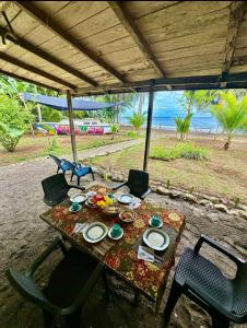a table and chairs with a table and a view of the beach at Hibiscus House Nuquí in Nuquí