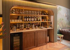a bar with a shelf with bottles and glasses at 5Q House Quinta Camacho in Bogotá +57 photos