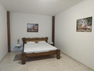 Ein Bett in einem weißen Zimmer mit zwei Bildern an der Wand in der Unterkunft Fortetsya in Uman + 111 Fotos