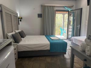 a bedroom with a bed and a door to a patio at Luxury Rooms Skidia Kekes Beach in Thymonia Beach