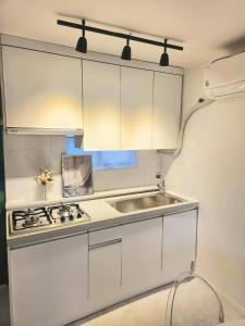 a kitchen with white cabinets and a sink at Haewol Stay in Suwon