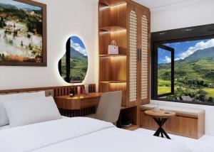 a bedroom with a bed and a desk and a window at En Hotel Sapa in Sapa