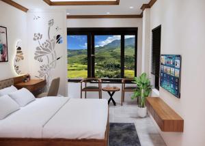 a bedroom with a bed and a desk with a view at En Hotel Sapa in Sapa