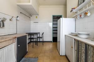 eine Küche mit Kühlschrank und Tisch in der Unterkunft Liberdade Home Royal direito in Braga
