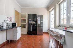 a kitchen with a large black refrigerator in a room at Imaculada Home Royal - Centro de Braga, Historico in Braga