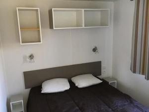 a bedroom with a bed with two pillows on it at Mobil-home pour 4 pers avec terrasse - API-1-52-739 in Avrillé