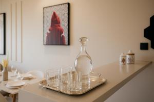 a glass bottle on a tray with glasses on a table at Utopia Stays - Clair, Calme, Précis in Casablanca