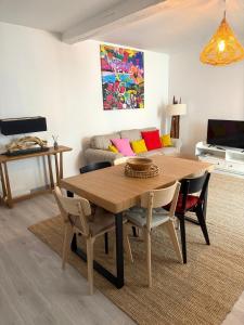 a living room with a wooden table and a couch at La Belle Escale in Pauillac