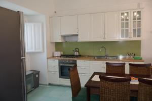 a kitchen with white cabinets and a table with chairs at Casa Flaùti Sorrento in Piano di Sorrento +20 photos