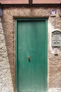 a green door on the side of a building at Casa Flaùti Sorrento in Piano di Sorrento