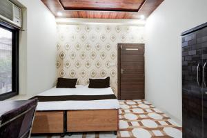 Habitación pequeña con cama y puerta en Hotel O Dwarika Mai Regidency, en Kota