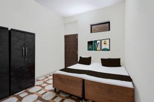 Un dormitorio con una cama y un armario negro. en Hotel O Dwarika Mai Regidency, en Kota