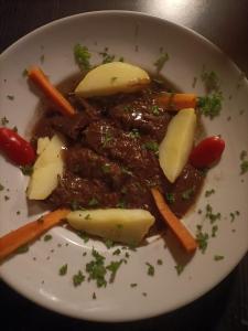a white plate of food with meat and vegetables at Les nuits calmes in La Châtre +8 photos