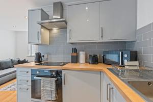 Una cocina con gabinetes blancos y encimera. en Leeds - Central - Free Parking - Sleeps 7, en Leeds 28 fotos más