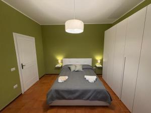a green bedroom with a bed with two towels on it at Una Rotonda sul Mare in Formia