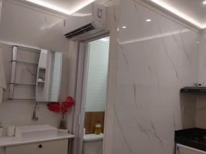 a white bathroom with a sink and a mirror at Studio 102 Cop 30 in Curro Velho
