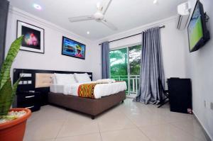 a bedroom with a bed and a large window at Chakaville Beach Resort in Iberekodo