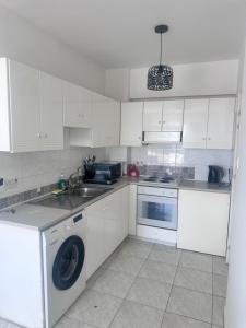 a white kitchen with a washing machine and a sink at Near Makenzie Beach 51 in Larnaka +23 photos