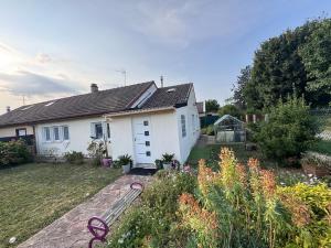 a white house with a garden in front of it at Séjour détente et confort au calme d une impasse in Garges-lès-Gonesse