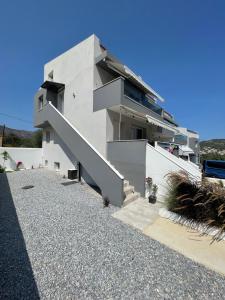 a white house with a staircase in front of it at Eternity fresh in Limenaria