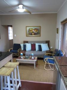 un soggiorno con un divano e un tavolo di Selah guest cottage...place to pause, breath relax a Bethulie