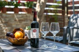 a bottle of wine and two wine glasses on a table at Gennadi Sea Escape in Gennadi +14 photos