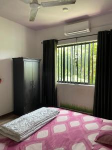 a bedroom with a large bed and a window at Highway View Transit Kiribathgoda in Kiribathgoda
