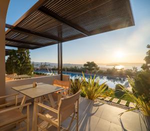 eine Terrasse mit Tisch und Stühlen und Meerblick in der Unterkunft Royal Sun in Chania