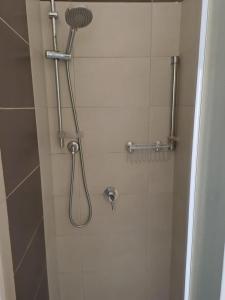 a shower with a shower head in a bathroom at Marialva Tropical T1 in Santa Maria