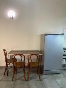 a table with two chairs and a refrigerator at Monoambiente en posadas 2 in Posadas